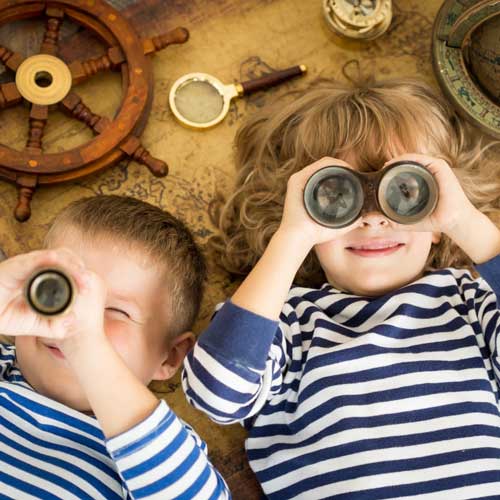 Zwei Kinder mit Fernglas im Matrosenkostüm